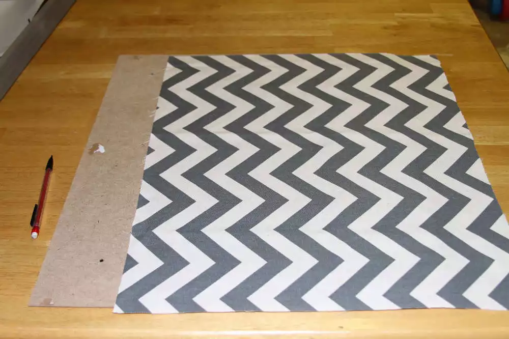 Attaching the fabric with tape to the baby shadow box backing