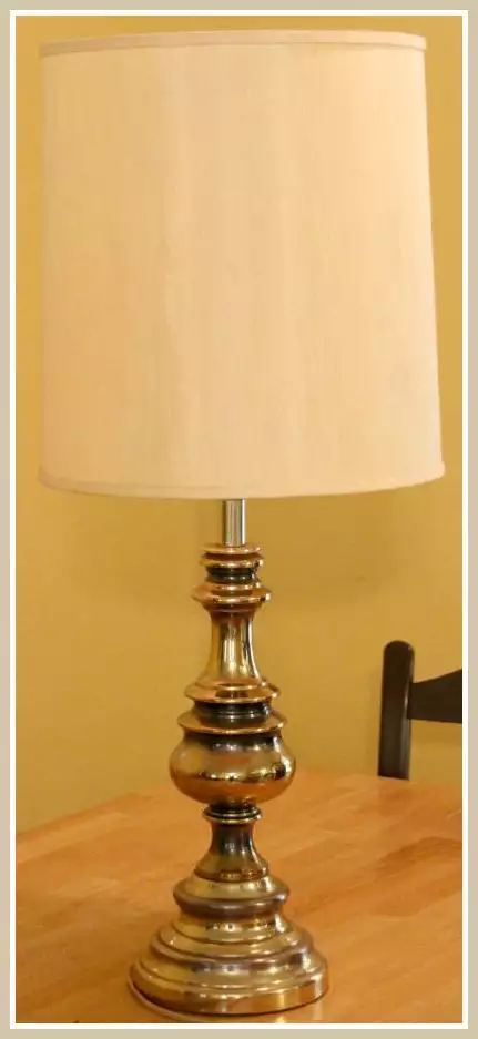 brass lamp with off white shade on table 