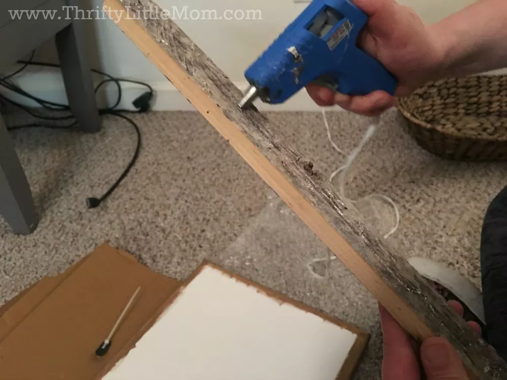 glueing reclaimed wood to canvas with hot glue gun