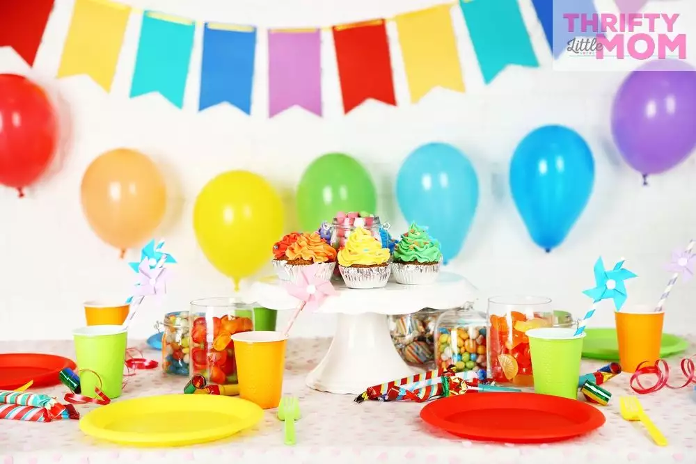 dessert table with rainbow theme party decorations