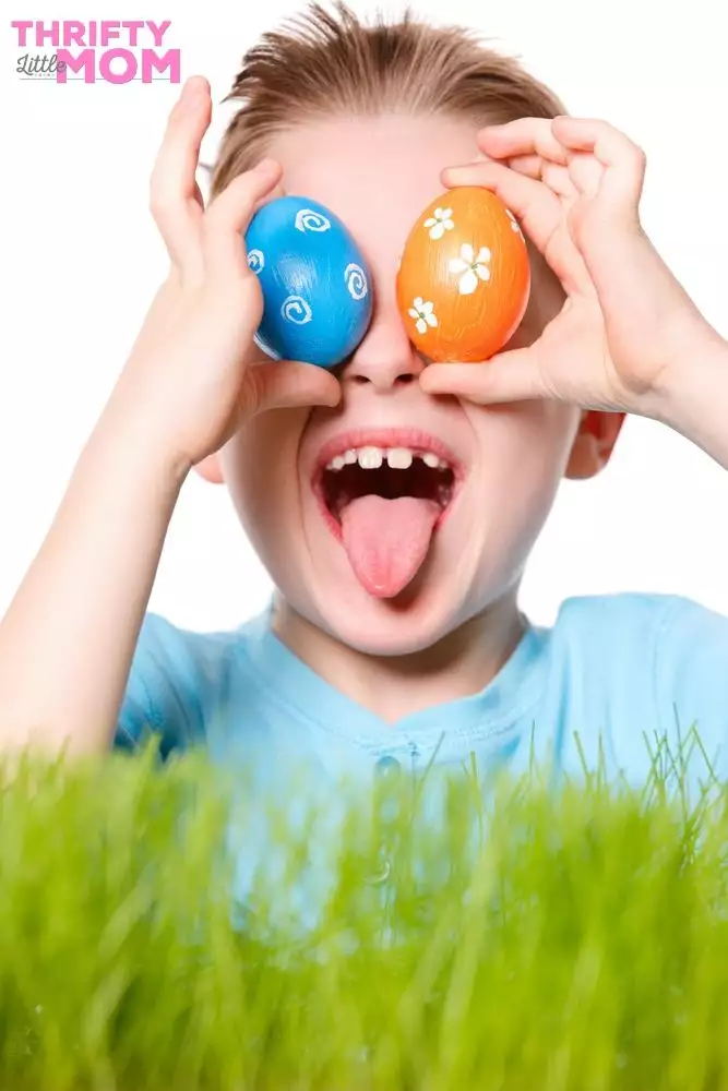 kid playing with two painted eggs for easter game