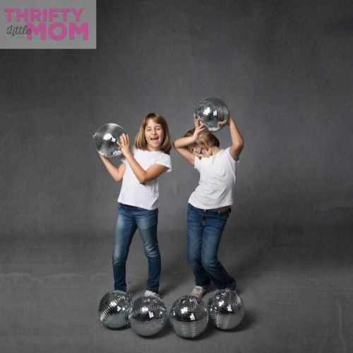 two kids playing with disco balls for a kids disco party
